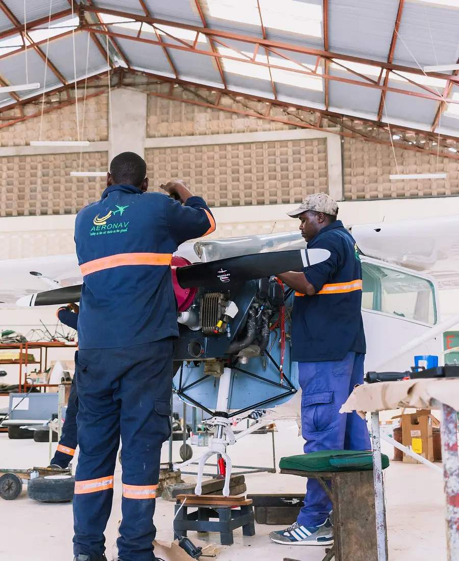 Dos técnicos trabajando en el motor de una avioneta en un hangar